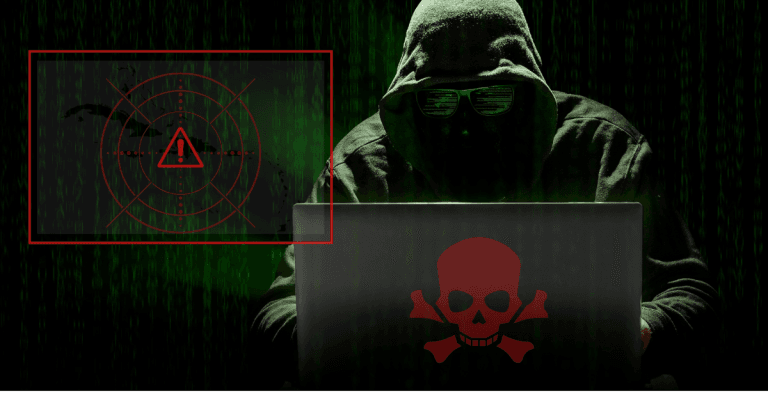 Hacker in dark hoodie using laptop with red skull icon, symbolizing ransomware threats targeting Caribbean businesses